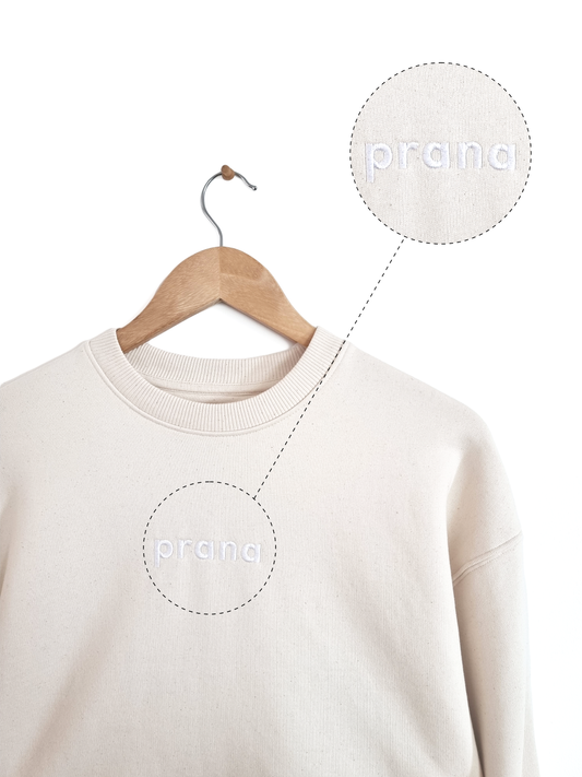 Ethical and sustainable, natural raw organic cotton sweater / sweatshirt with an embroidered prana design for yoga, gym, or lounge wear.